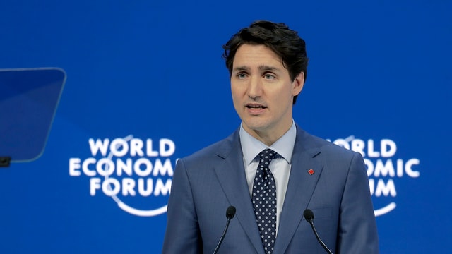 Justin Trudeau davant ina paraid blaua cun il logo dal WEF.