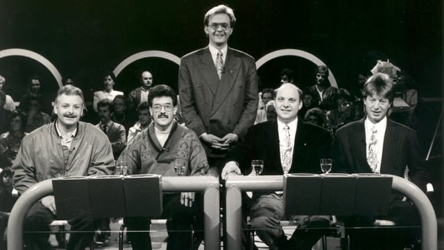 Il moderatur da l'emissiun «Contacts» Mariano Tschuor cun quatter giasts l'onn 1980. Il moderatur da l'emissiun «Contacts» Mariano Tschuor cun quatter giasts l'onn 1980.