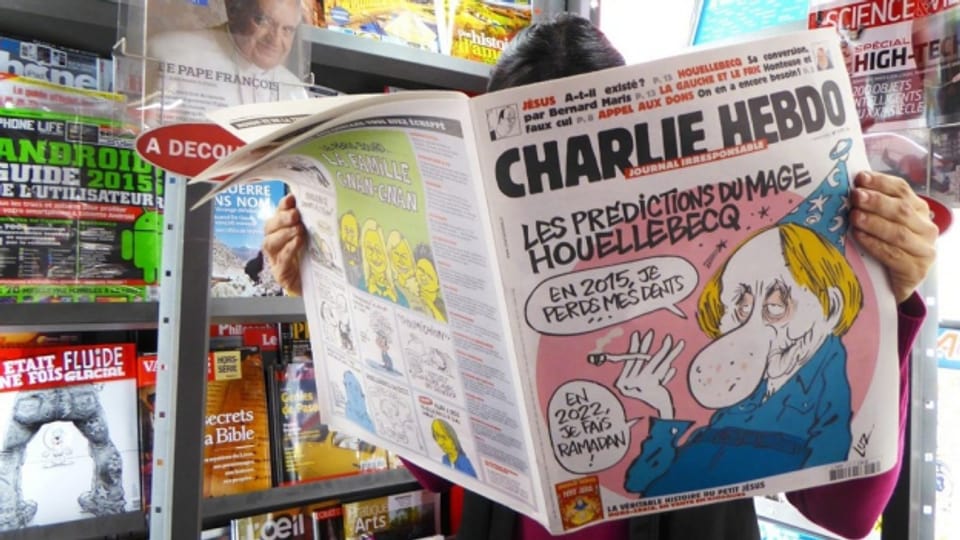 Persuna che legia il magazin Charlie Hebdo.