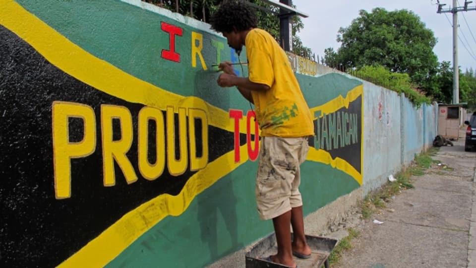 In um da la Jamaica colurescha ina preit cun la bandiera naziunala