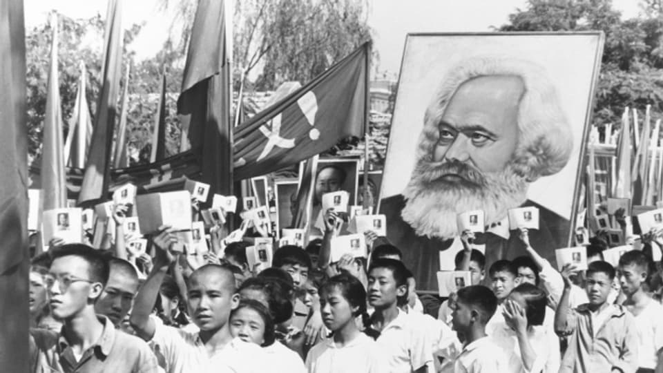 Ina manifestaziun da lavurers en China cun in purtret da Karl Marx