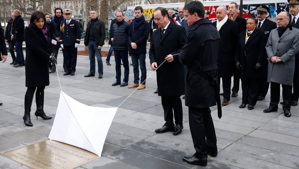 Il president François Hollande, il primminister Manuel Valls e la burgamestra da Paris Anne Hidalgo svelan la tavla commemorativa.