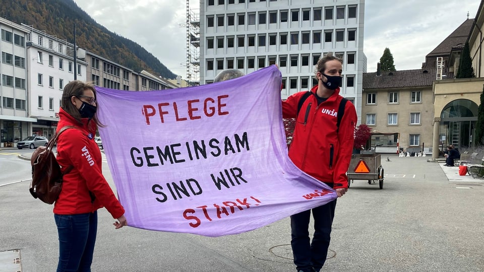 Duas persunas tegnan in placat per far attent sin la tgira