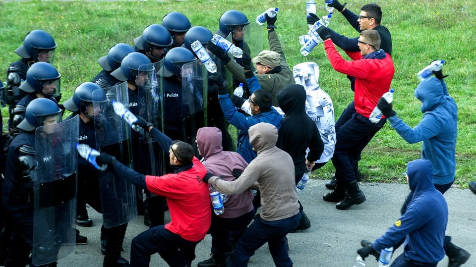 Symbolbild: Polizeianwaerter im Einsatz gegen eine fiktive Gruppe von Hooligans