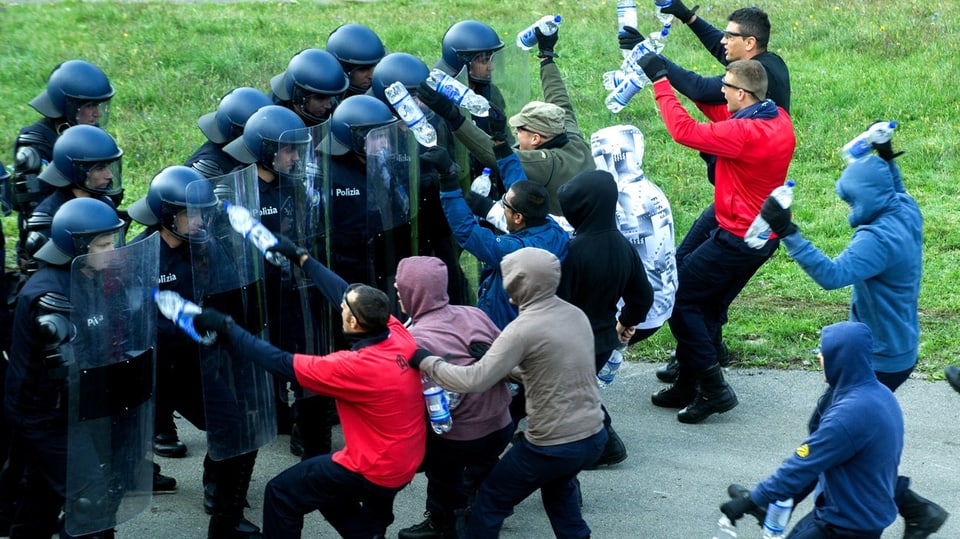 Symbolbild: Polizeianwaerter im Einsatz gegen eine fiktive Gruppe von Hooligans