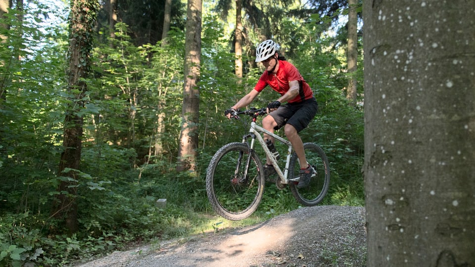 Il maletg mussa ina dunna sin il mountainbike.