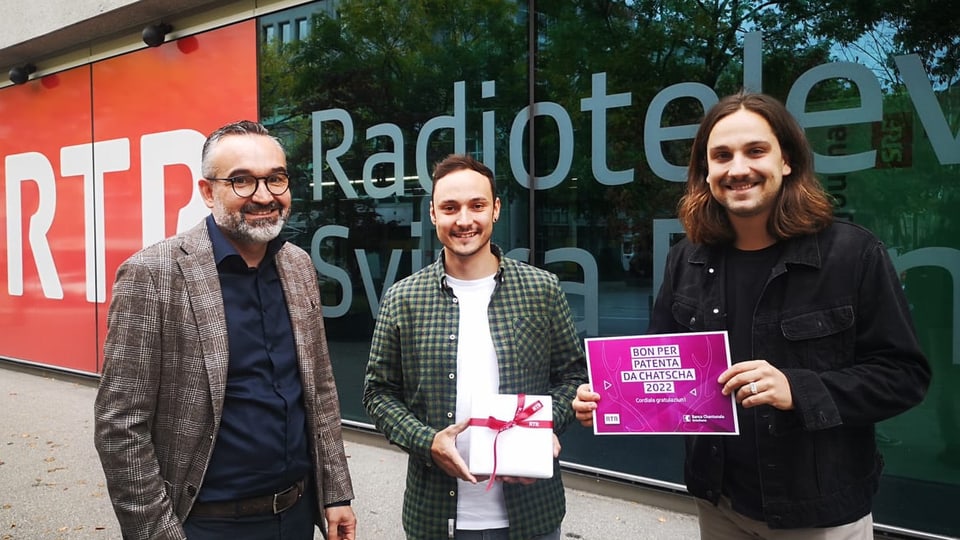 Christian Alig da la GKB, Kevin Giger (victur) ed il moderatur da RTR Elias Tsoutsaios. 