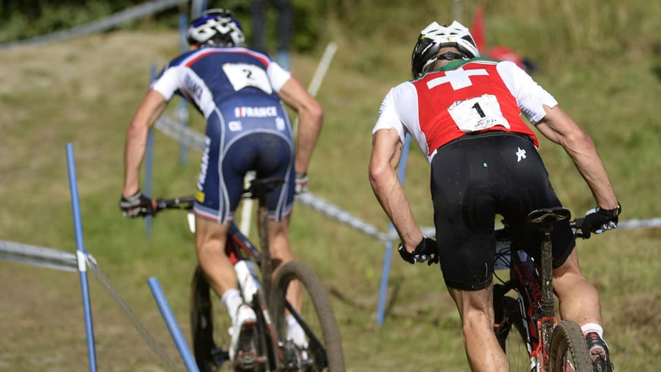 Nino Schurter en ina cursa da mountainbike davos Julien Absalon.