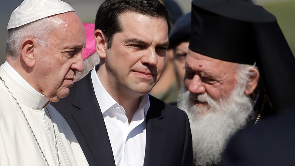 Fan bainvegni a Papa Francestg: Il primminister grec Alexis Tsipras (mez) ed l'archuvestg Ieronimos (dre.).