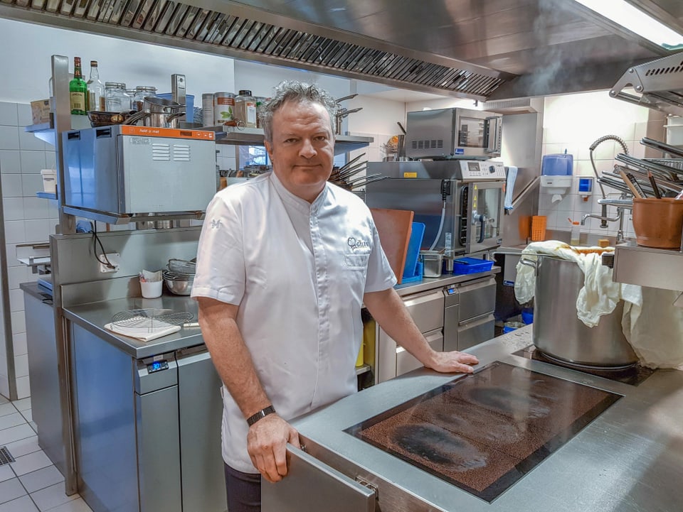 Linus Arpagaus en mondura da cuschinier en sia cuschina dal Hotel Casutt