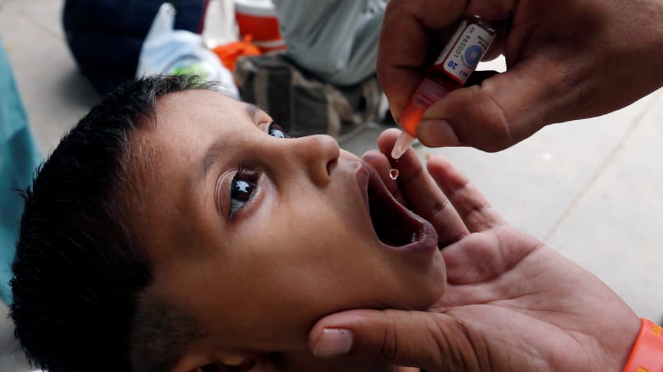 In uffant che survign daguts da la vaccinaziun en bucca.