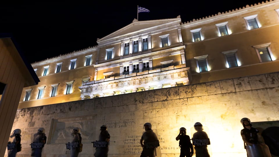 Polizia avant il bajetg dal parlament grec ad Athen.