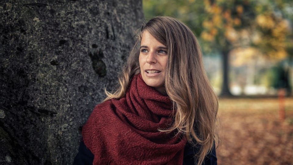 Jessica Zuan an Baum gelehnt.
