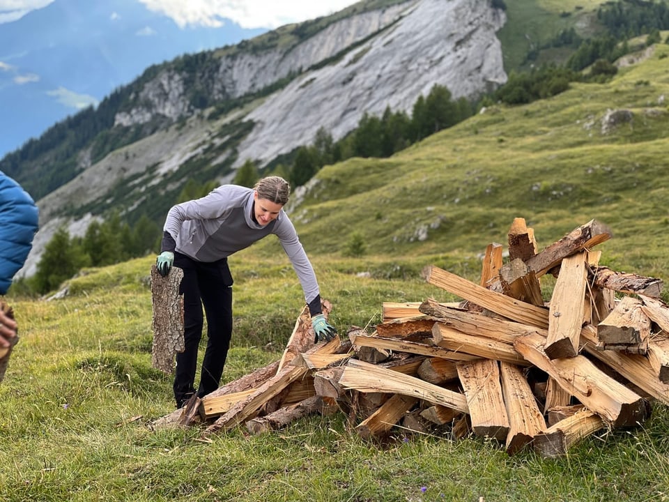 Eine Frau trägt Holz zum Höhenfeuer.