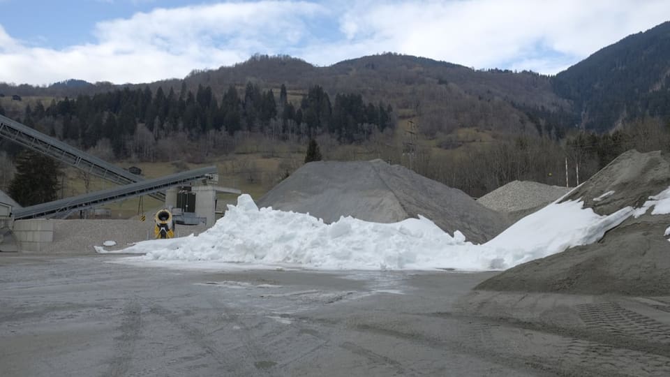 Schneekanone mit Schneeresten in einem Kieswerk. 