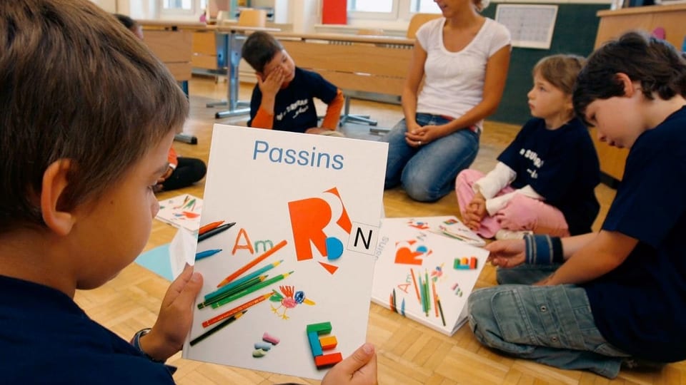 Scolars a Brinzauls cun il cudesch d'instrucziun.