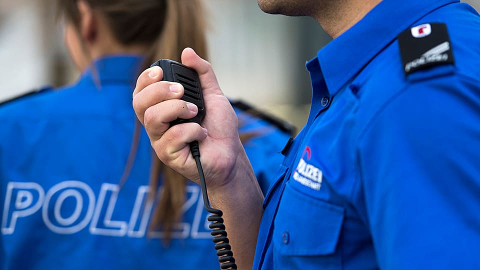 Dus policists dal chantun Basilea. In policist telefonescha.