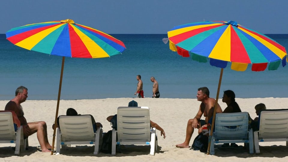 Persunas che fan vacanzas sper la mar.