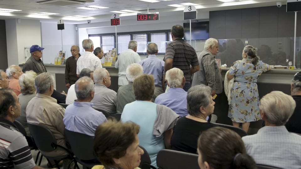 Grecs e Grecas spetgan en ina banca.