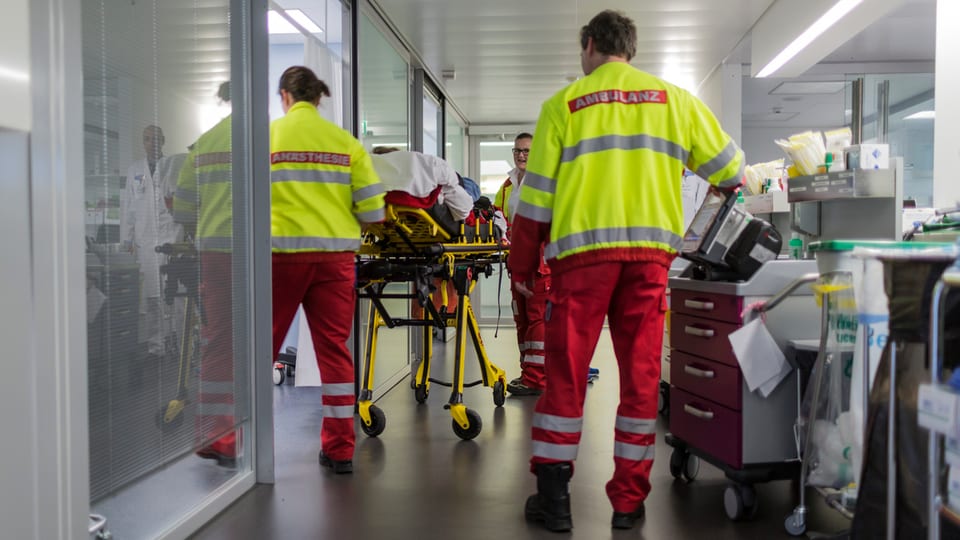 Partiziun d'urgenza en in ospital cun impiegads d'ambulanza.