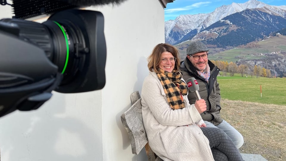 La redactura Esther Berther en discurs cun Ursin Derungs in um ed ina dunna sin in baun