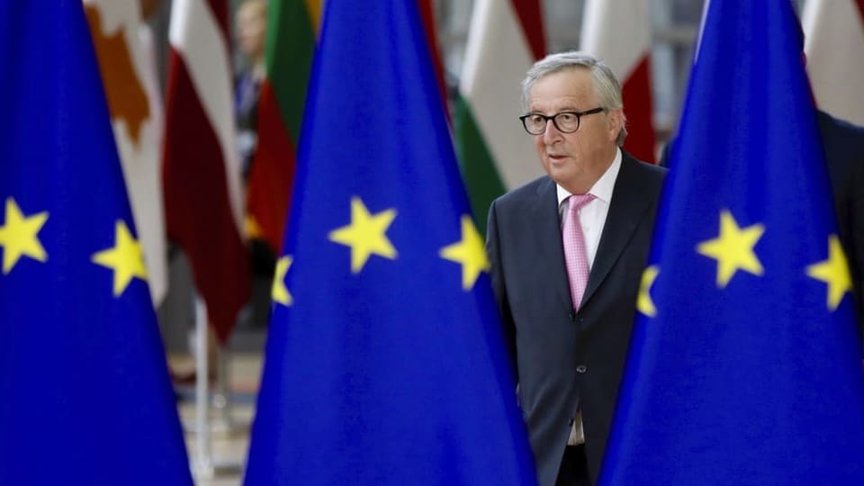 Juncker e trasi bandieras da l'UE.