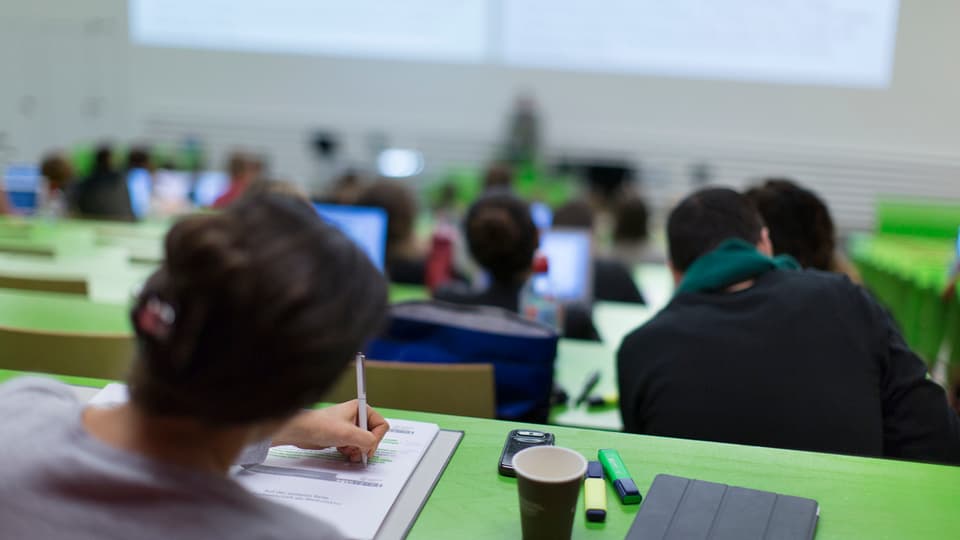 Students da l'ETH da Turitg durant ina lecziun - ins vesa els da davos, lur pults èn cler-verds