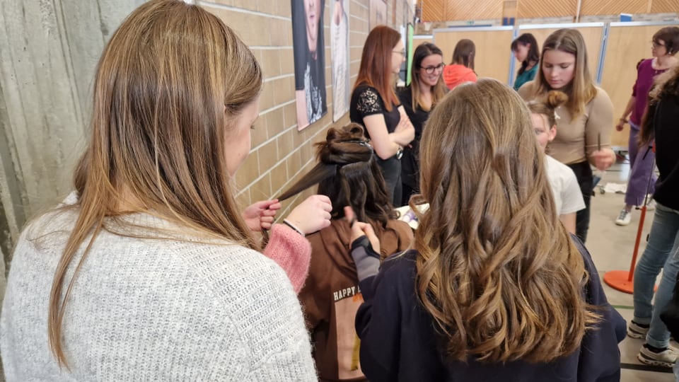Schülerinnen machen einander Locken in die Haare.
