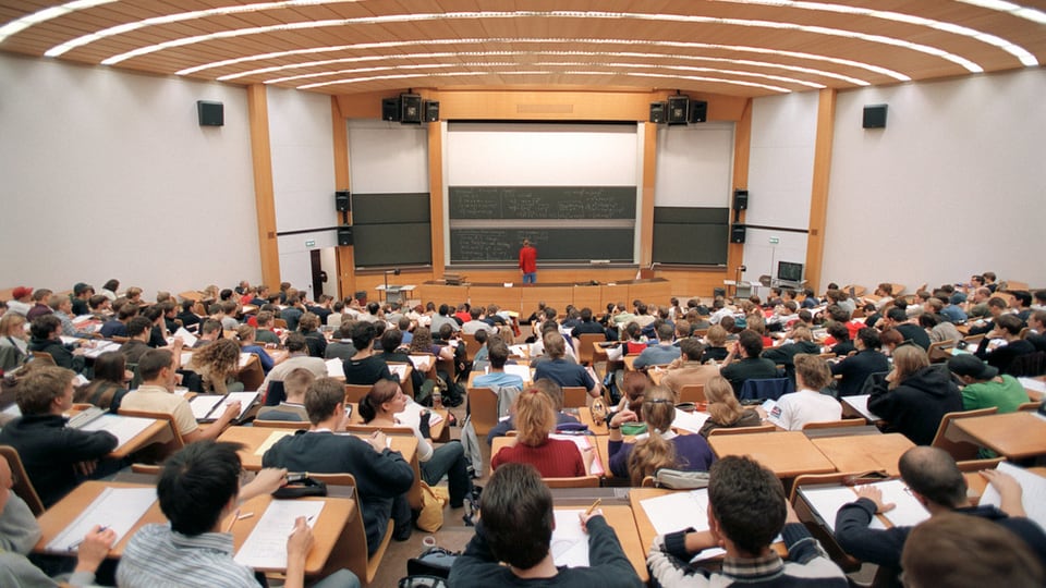 Sala da prelecziun cun students che guardan giu tar il dozent.