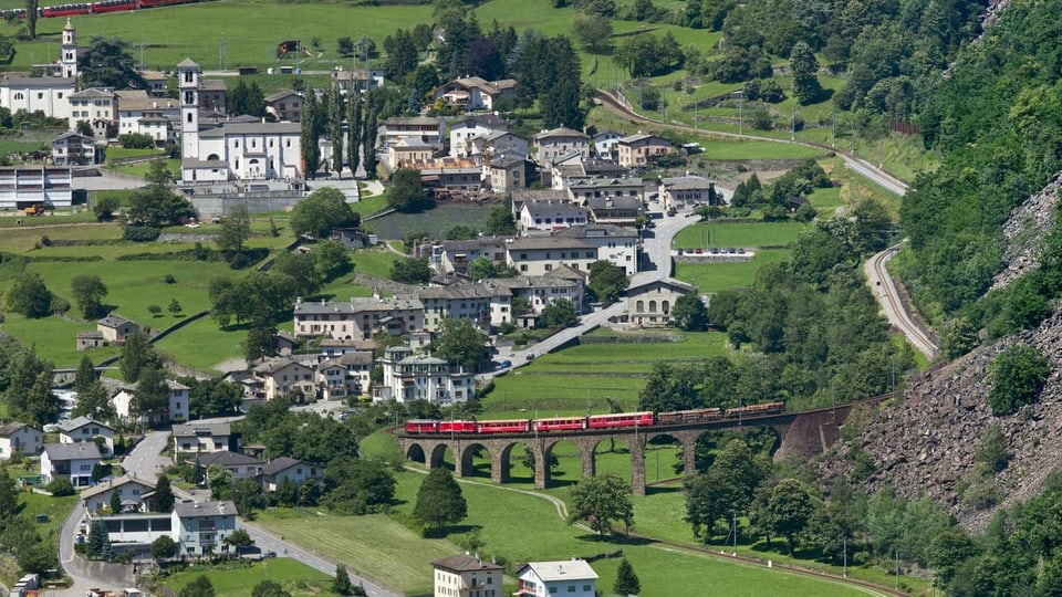 Vista sin Brusio cun in tren sin il viaduct famus da la viafier retica.