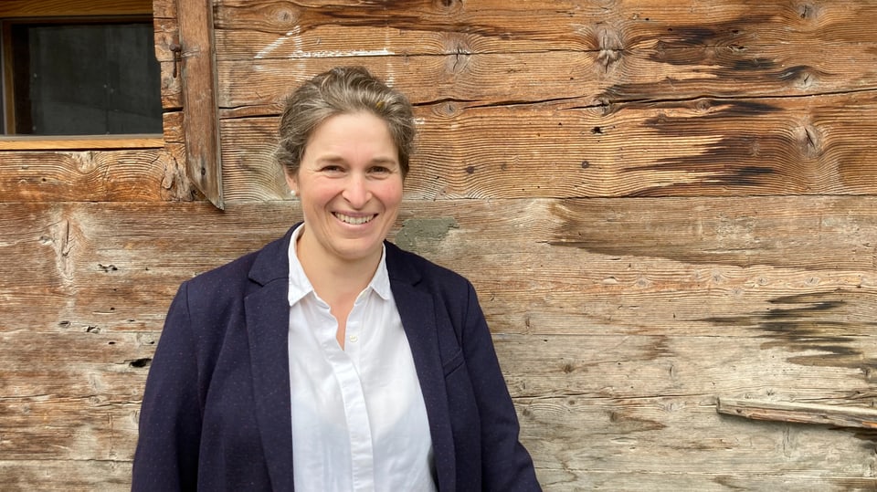Margit Geiger Frau mit weisser bluse und blauem blaser vor alter holzwand