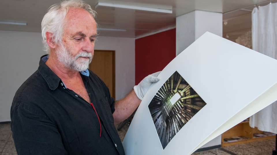 Fridolin Walcher vid preparar las fotografias per l'exposiziun a Glion.