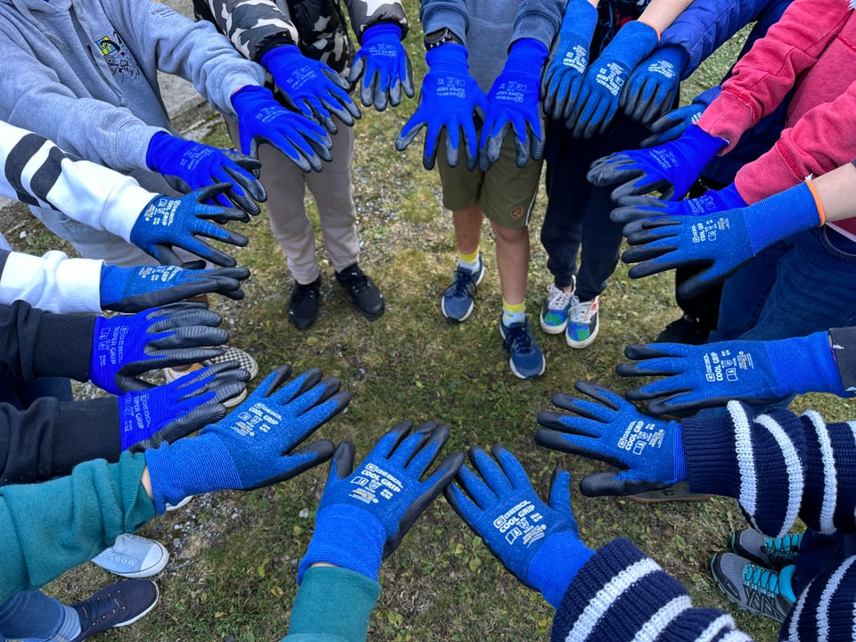 Blaue Handschuhe bilden einen Kreis. 