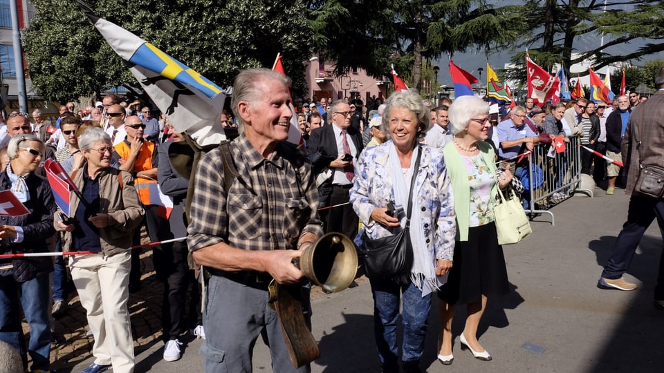 Purtret dad Aldo Bianchi cun ina plumpa ed ina bandera grischuna enta maun. 