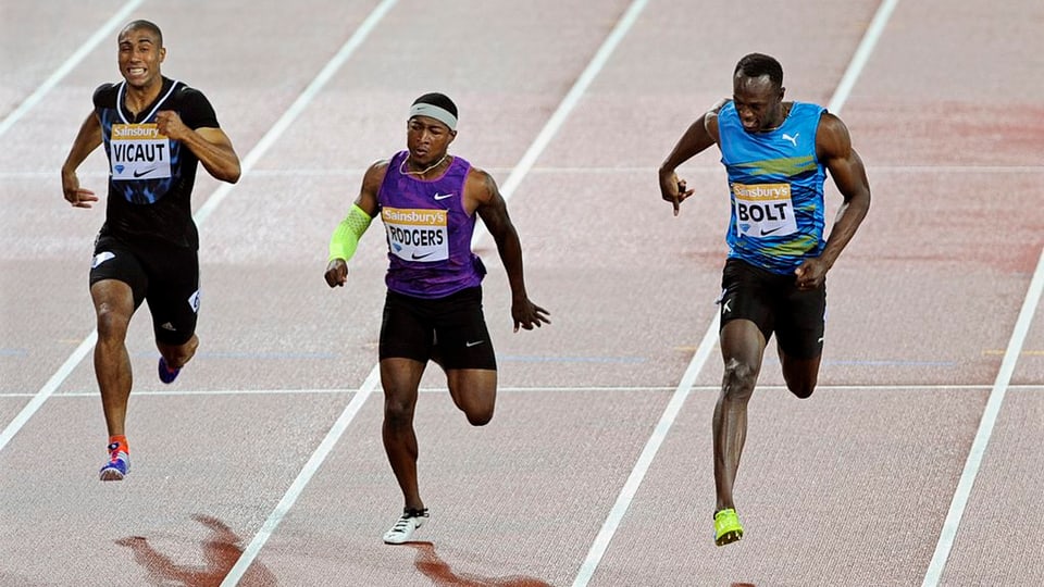 Usain Bolt (dretg) arriva avant Michael Rogers (entamez) en l'arrivada.