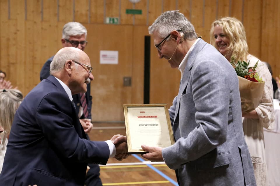 Gion Tscharner bekommt den Preis von Vincent Augustin. 