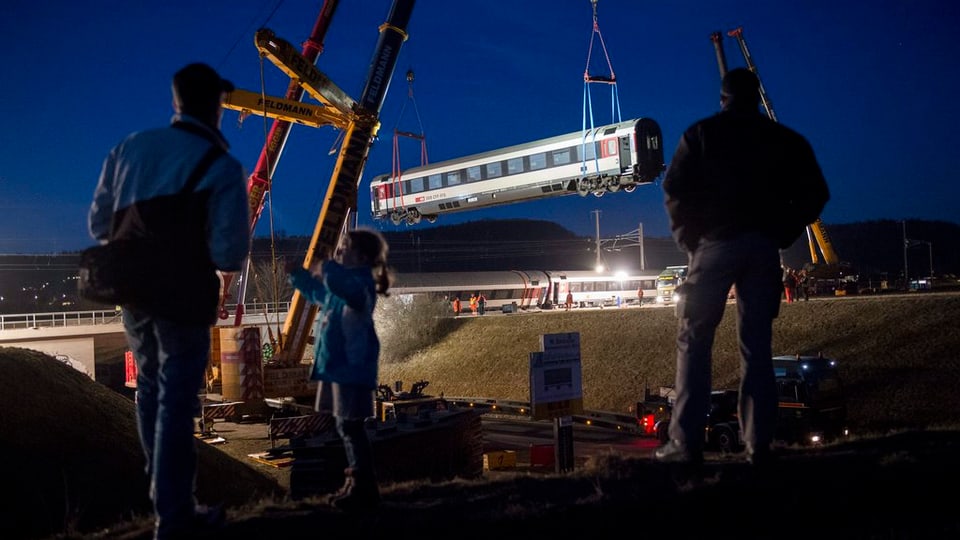 Ina crana che transporta davent in vagun dals trens collidads a Rafz.