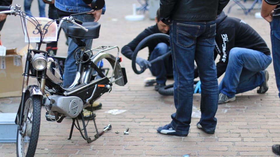 Trais participants da la tura midan in pneu d'in moped avant la partenza