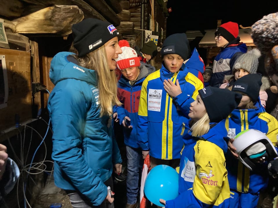 kinder in gelb blauen jacken, frau mit blonden haaren und blauer jacke