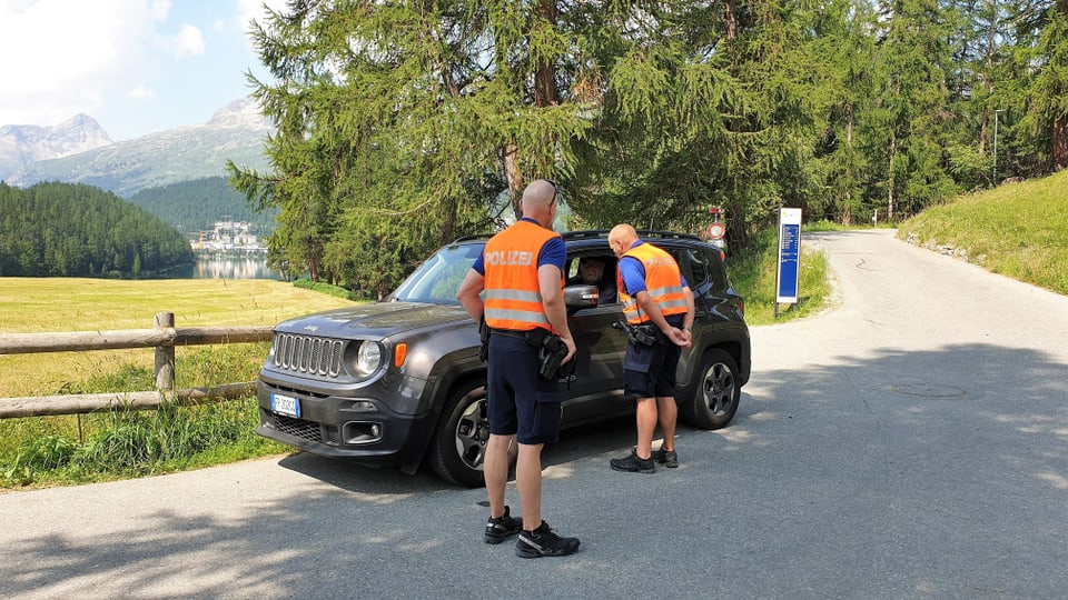 Ils dus policists han fermà in auto e til controllan. In stà daspera entant che l'auter discurra cun il manischunz.