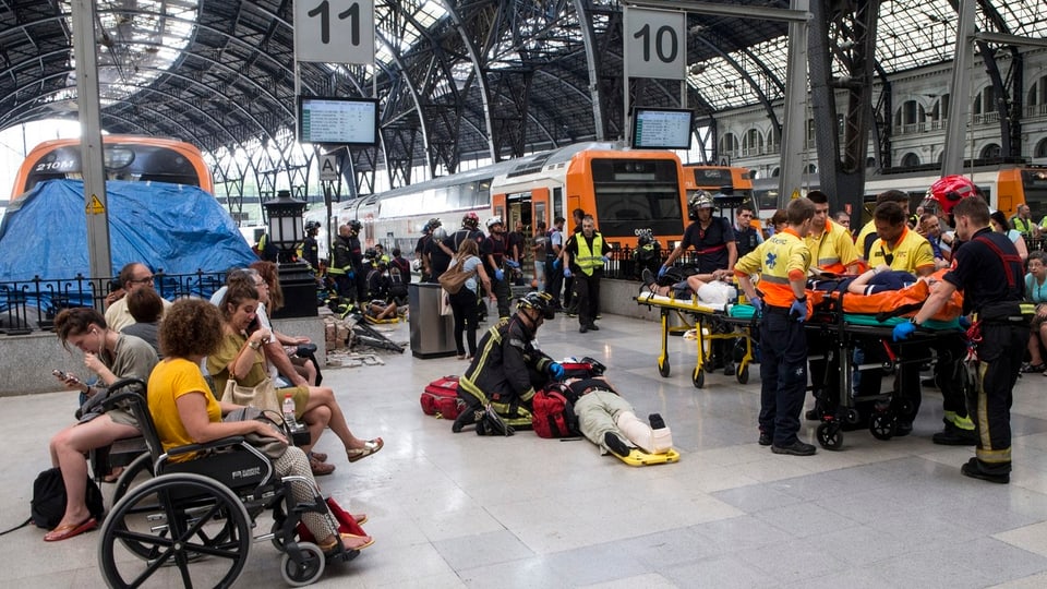 Persunas salvadas e medis en la staziun da Barcelona.