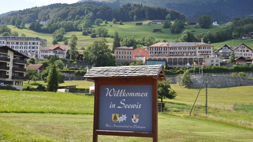 Purtret da la tabla a l'entschatta dal vitg da Seewis cun scrit si: «Willkommen in Seewis».