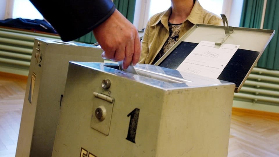 In maun che bitta il scrit da votar en l'urna.