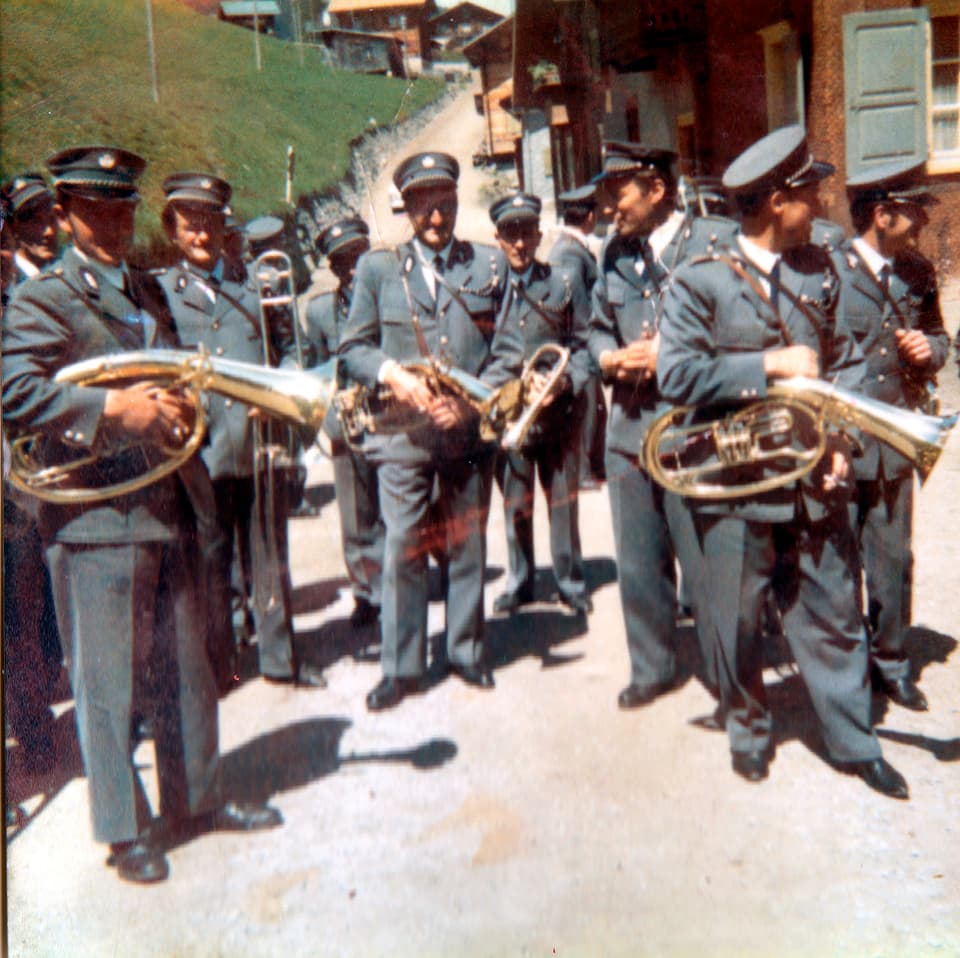 Bild aus den 60er Jahren, einige Musikanten stehen beisammen, alle in grauer Uniform