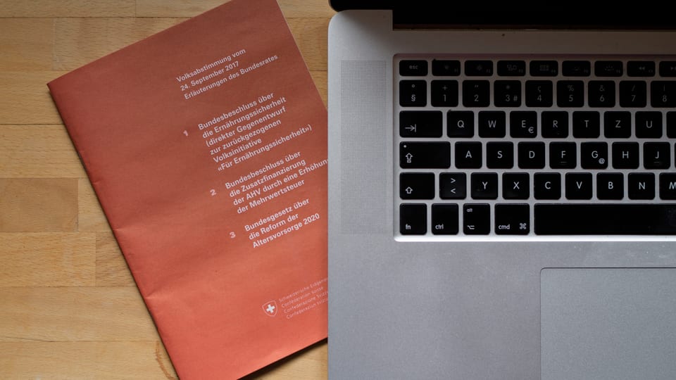 in cudeschet da votaziun sper in laptop