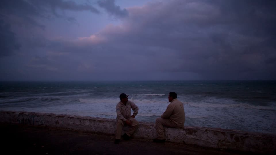 Dus umens che sesan a l'ur da la mar.