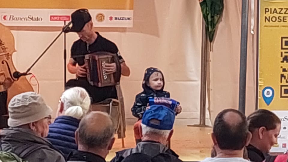 Kleinkind spielt Schwyzerörgeli auf einer Bühne in Bellinzona