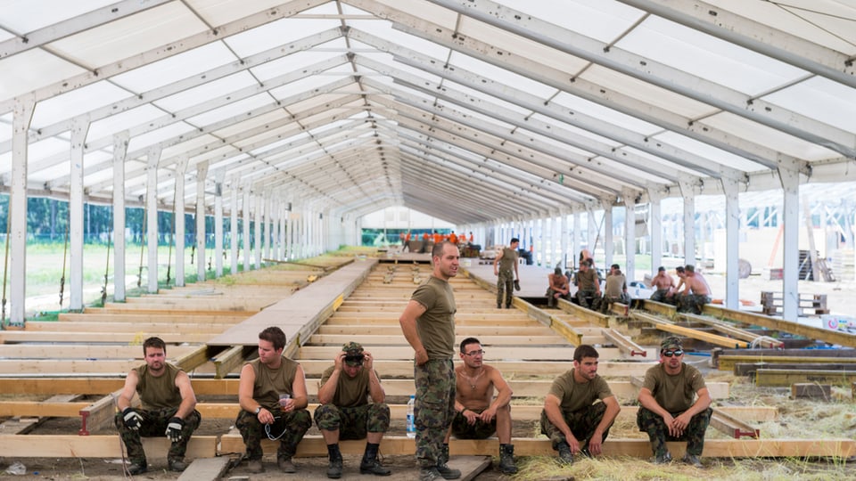 Schuldada fa ina pausa, davostiers ina tenda da festa en construcziun. 