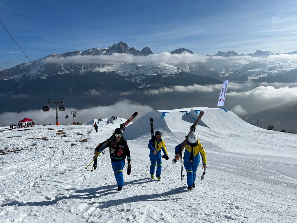 Skilehrer und Skilehrerinnen aus Breil/Brigels laufen eine Piste hoch.