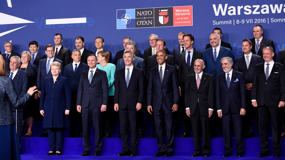 La uschenumnada fotografia da famiglia cun si ils partecipants pli impurtants gruppats enturn Obama.